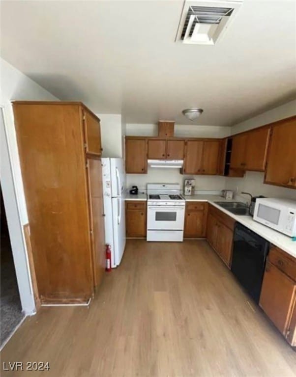 kitchen with white appliances, sink, and light hardwood / wood-style floors