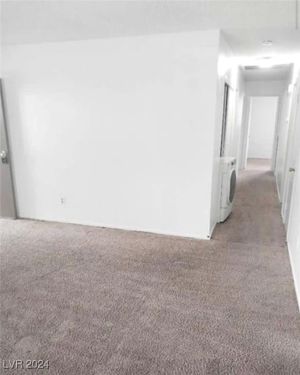 empty room featuring washer / clothes dryer and carpet