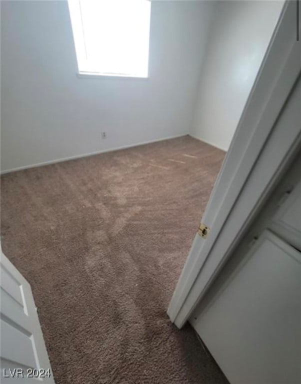 unfurnished room featuring dark carpet