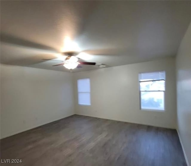 empty room with dark hardwood / wood-style floors and ceiling fan