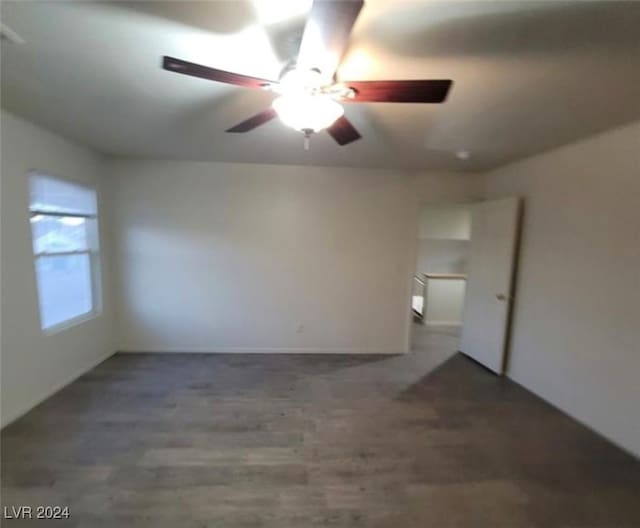 unfurnished room with ceiling fan and dark wood-type flooring