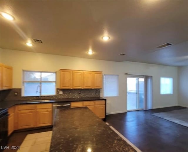 kitchen featuring tasteful backsplash, dark wood-type flooring, light brown cabinets, sink, and stainless steel dishwasher