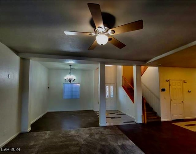 interior space with ceiling fan with notable chandelier