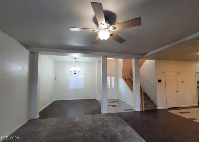 basement featuring ceiling fan with notable chandelier