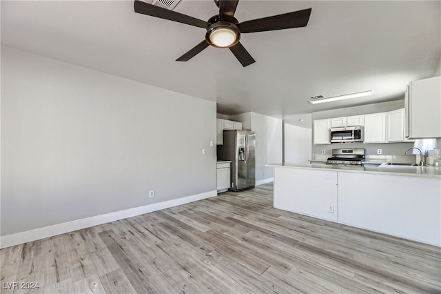 kitchen featuring light hardwood / wood-style floors, sink, stainless steel appliances, kitchen peninsula, and white cabinets