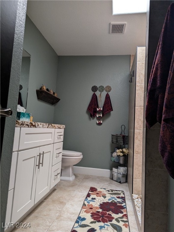 bathroom featuring a shower, tile patterned flooring, vanity, and toilet