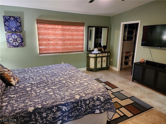 bedroom with a walk in closet, ceiling fan, and a closet