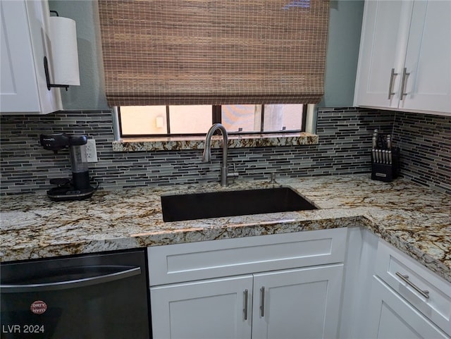 kitchen with white cabinets, sink, black dishwasher, and tasteful backsplash