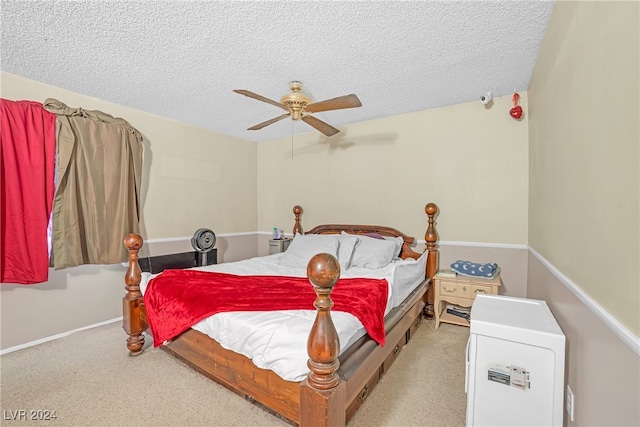 bedroom with ceiling fan, light colored carpet, and a textured ceiling