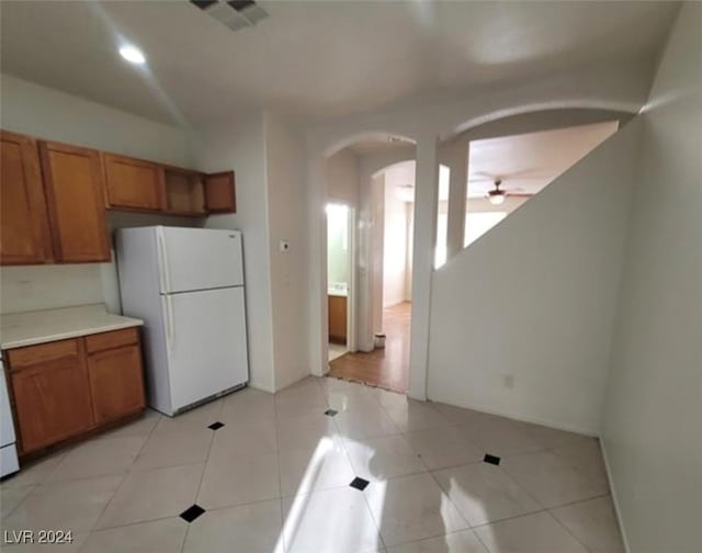 kitchen with white fridge, light tile patterned floors, and ceiling fan