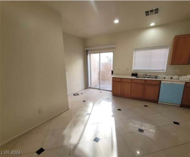 kitchen with dishwasher, sink, and light tile patterned floors