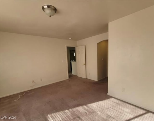 spare room with dark colored carpet