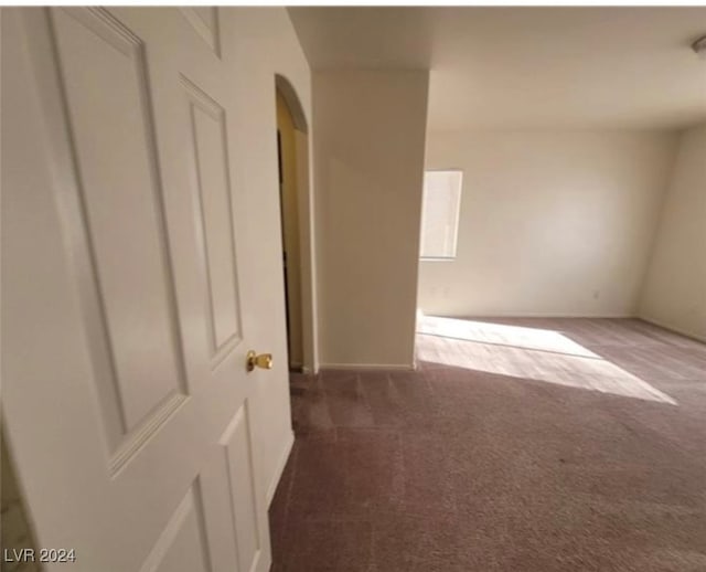 spare room featuring dark carpet