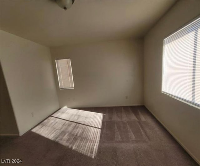 unfurnished room with dark carpet