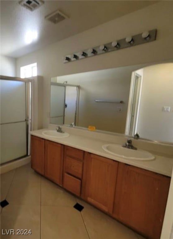 bathroom featuring walk in shower, vanity, and tile patterned floors