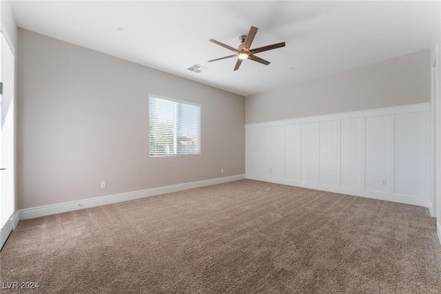 carpeted spare room featuring ceiling fan