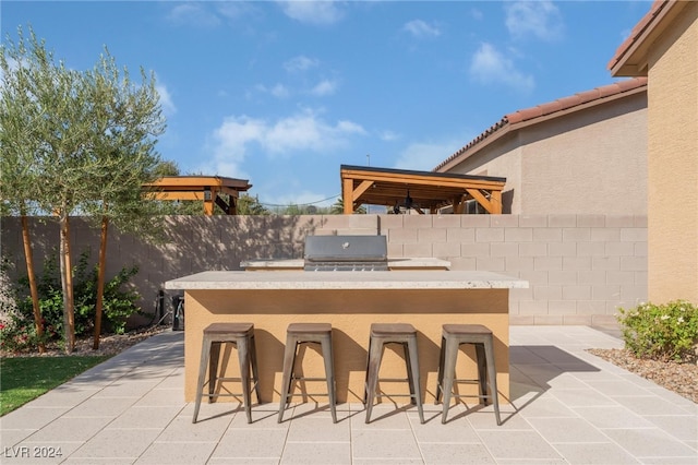 view of patio with a bar and area for grilling