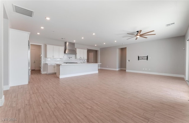 unfurnished living room with sink, light hardwood / wood-style flooring, and ceiling fan