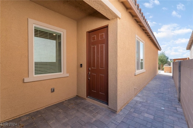 view of exterior entry featuring a patio area