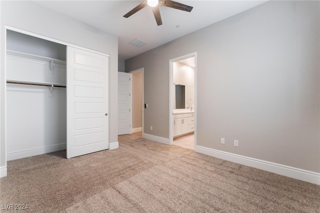 unfurnished bedroom with light carpet, a closet, ceiling fan, and ensuite bathroom