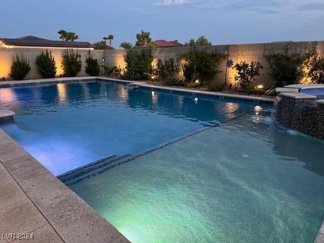 view of pool at dusk