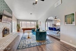 living room featuring a brick fireplace, ceiling fan, and hardwood / wood-style floors