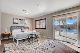 bedroom with access to outside, light wood-type flooring, and multiple windows