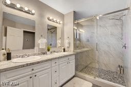 bathroom featuring vanity and a shower with door