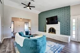 living room with a fireplace, vaulted ceiling, hardwood / wood-style flooring, and ceiling fan