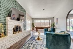 living room with lofted ceiling, hardwood / wood-style floors, and a fireplace