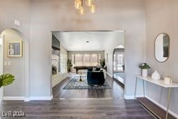 corridor featuring a notable chandelier and dark wood-type flooring