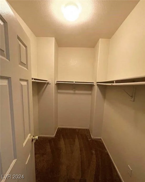 spacious closet featuring dark carpet