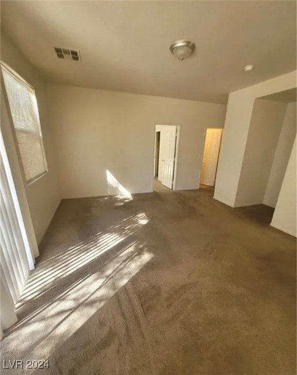 unfurnished room with dark carpet