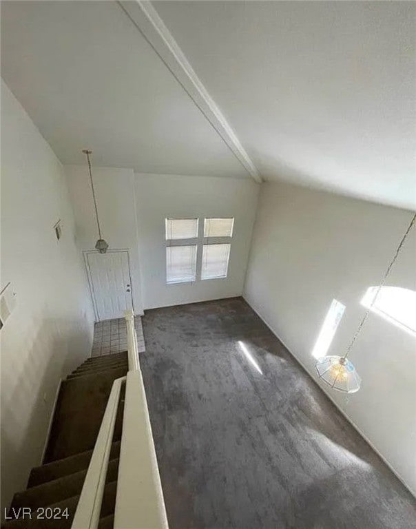 interior space with lofted ceiling and dark carpet