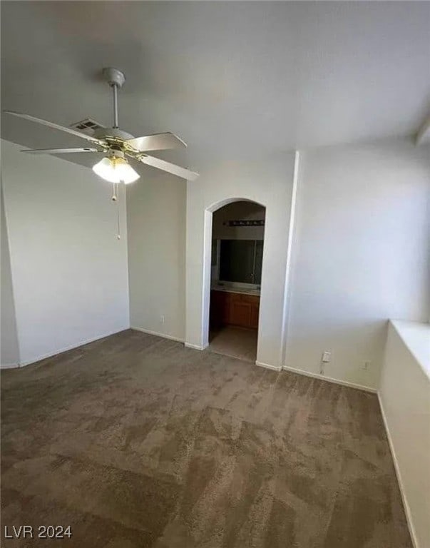 carpeted spare room featuring ceiling fan