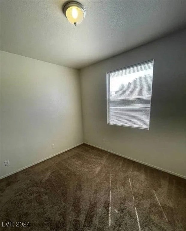 carpeted empty room with a textured ceiling