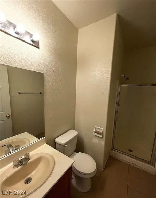 bathroom featuring tile patterned floors, a shower with shower door, vanity, and toilet