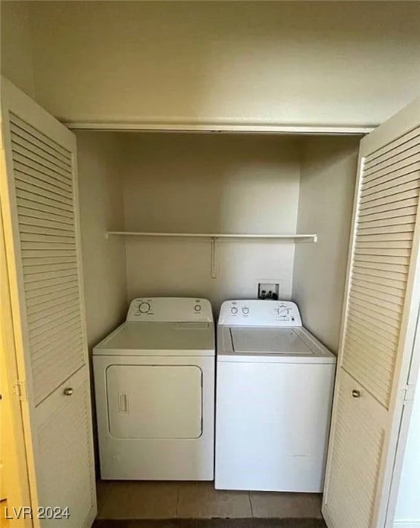 laundry room with separate washer and dryer and dark tile patterned flooring