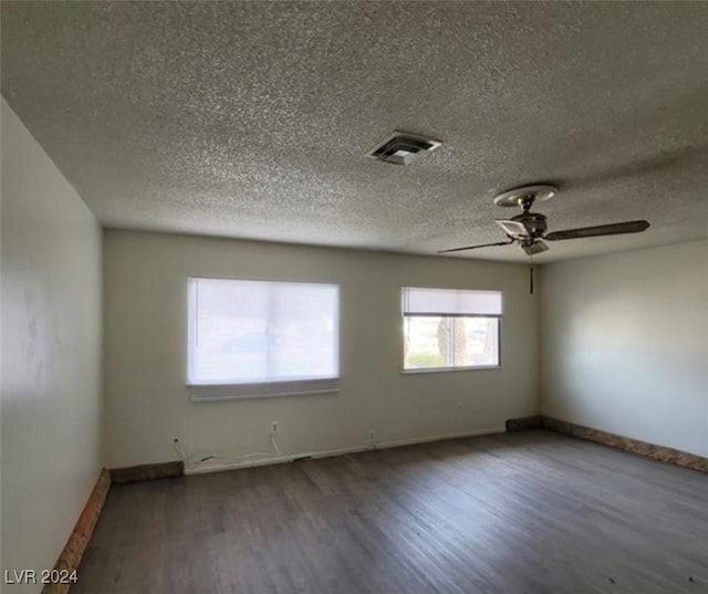 empty room with ceiling fan, hardwood / wood-style flooring, and a textured ceiling