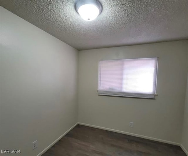 unfurnished room with dark hardwood / wood-style floors and a textured ceiling