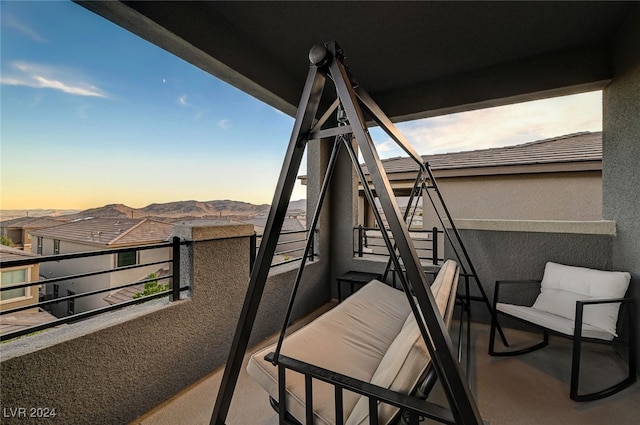 balcony at dusk featuring a mountain view