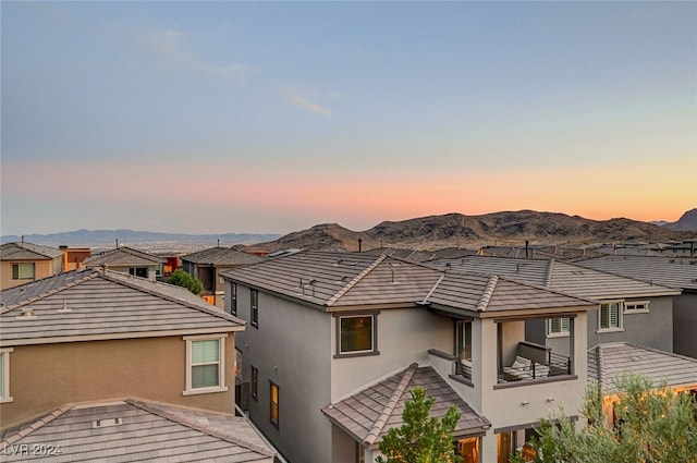 property exterior at dusk with a mountain view