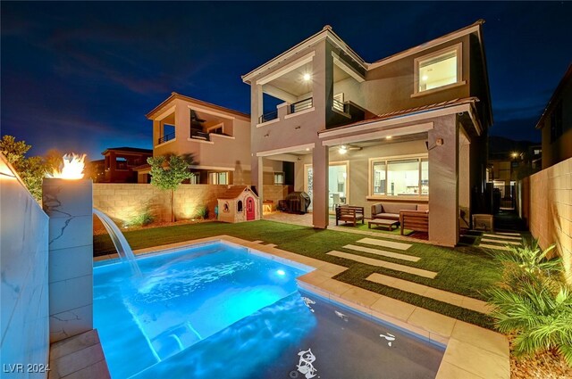 rear view of property featuring a fenced in pool, an outdoor hangout area, a balcony, a patio area, and pool water feature