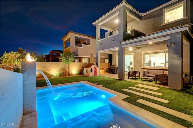 view of swimming pool featuring a patio, a storage shed, pool water feature, an outdoor hangout area, and a lawn