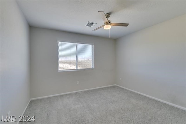 empty room with ceiling fan and light carpet