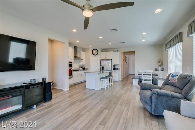 living room featuring ceiling fan and light hardwood / wood-style floors