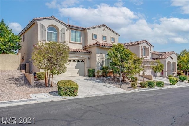 mediterranean / spanish-style home with a garage