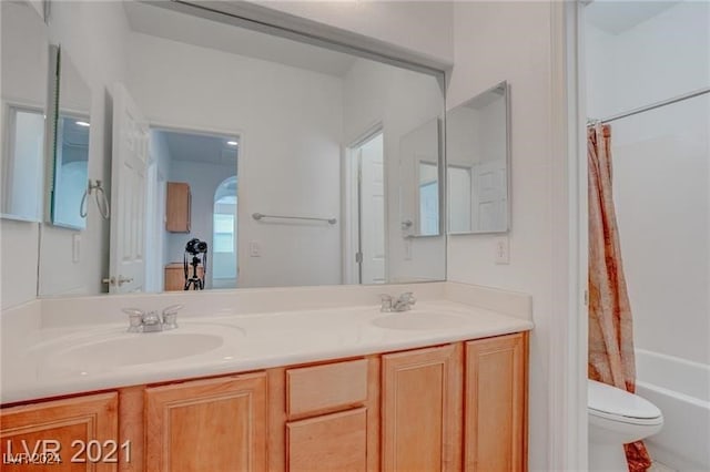 full bathroom with vanity, shower / tub combo, and toilet