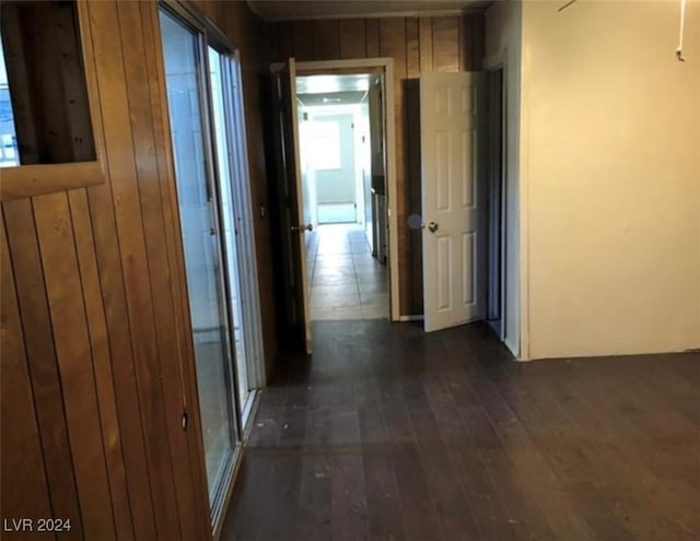 hallway with wood walls and dark hardwood / wood-style floors