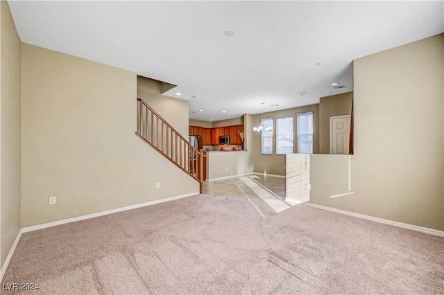 unfurnished living room featuring a chandelier and light carpet